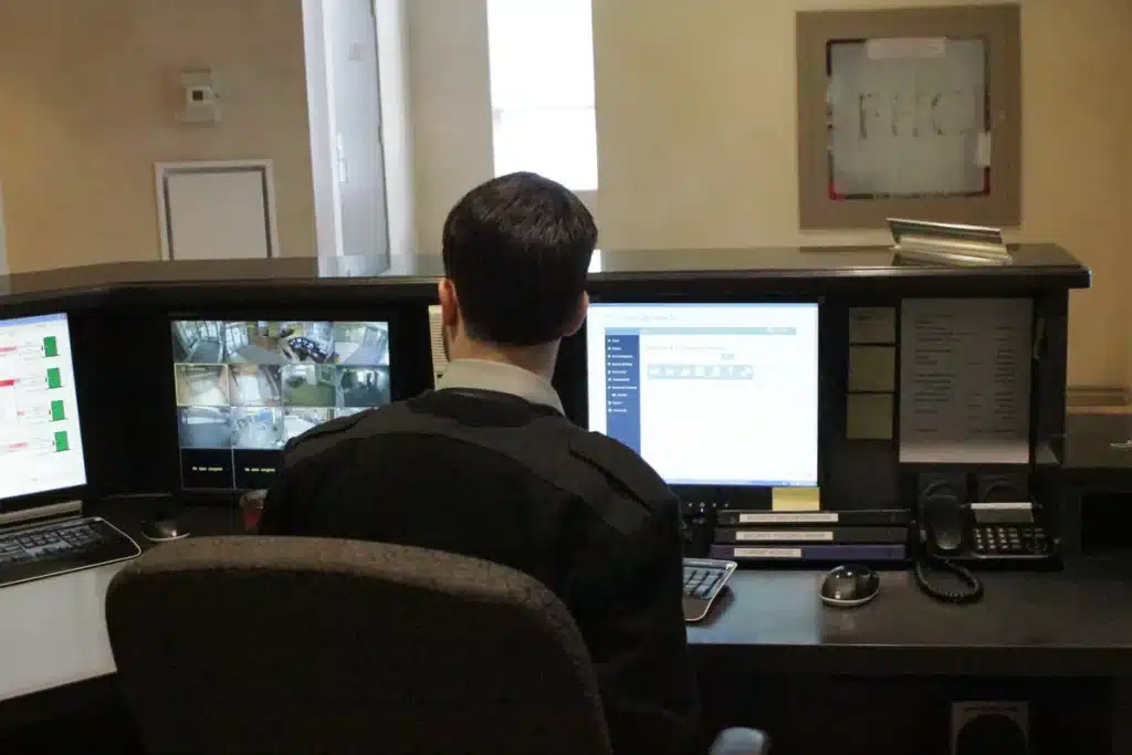 Security guard at condominium front desk monitoring intercom and access control systems in Toronto